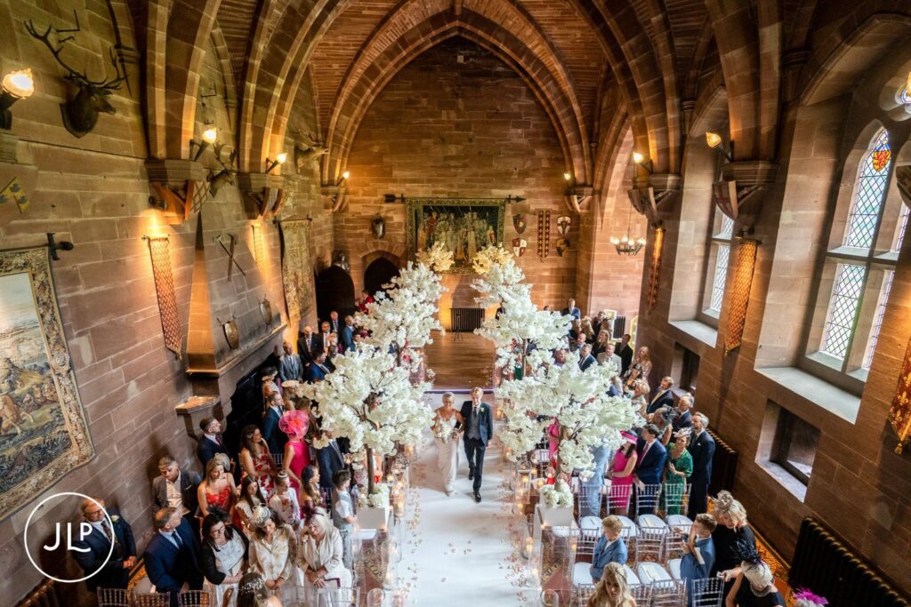 High-angle shot of the bride walking down the aisle during a luxury castle wedding in Cheshire.