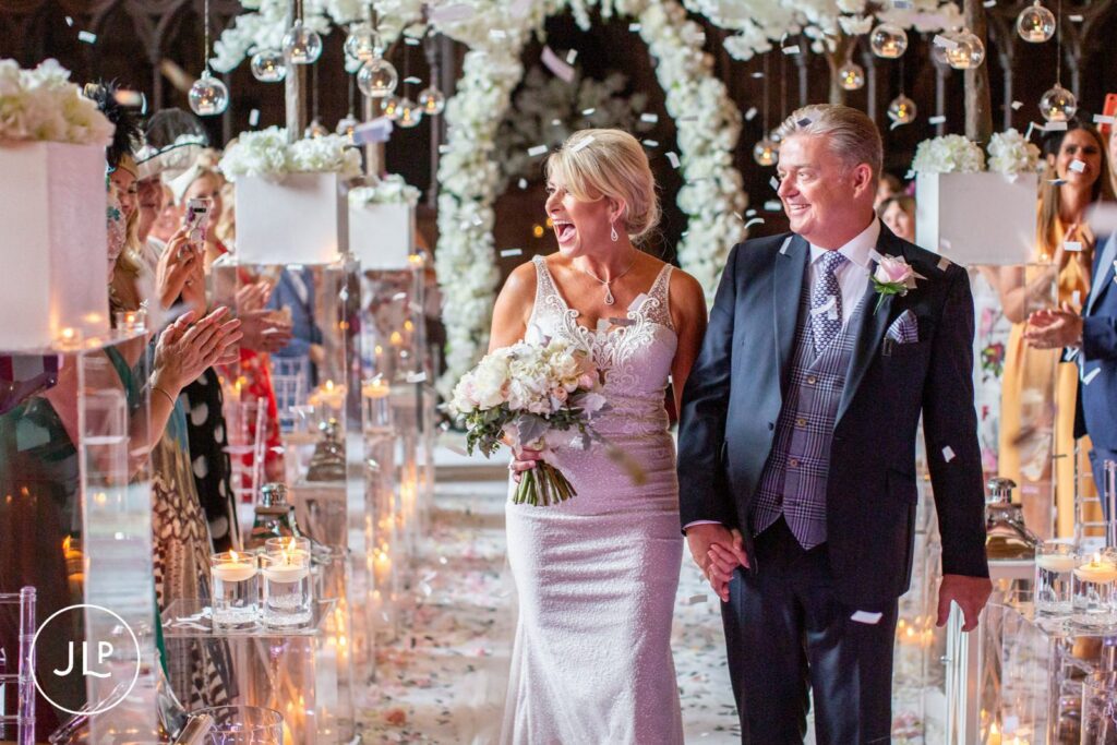 Candid wedding photography of a joyful bride and groom walking up the aisle as husband and wife.