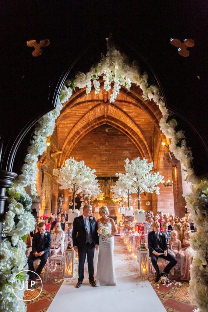 Peckforton Castle wedding photographer captures the newlyweds standing at the altar in the historic hall.