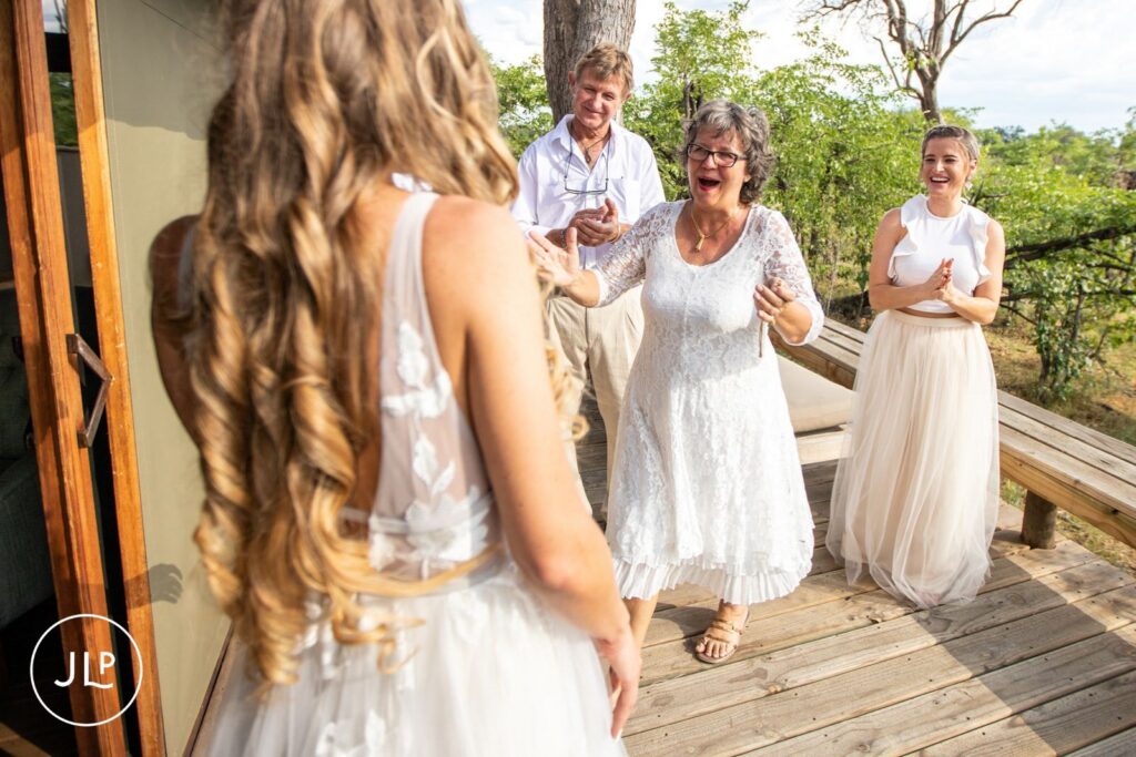 An emotional mother reacts with joy seeing the bride, captured by a Botswana destination wedding photographer.