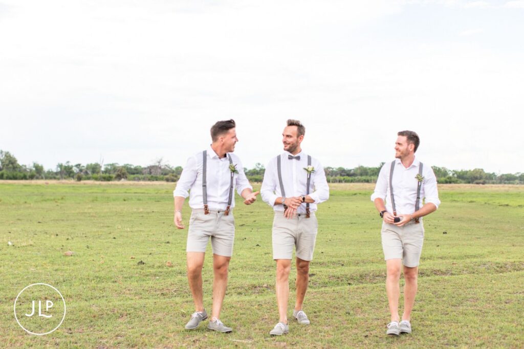 A groom and his groomsmen walking across the grass, by a Botswana safari wedding photographer.