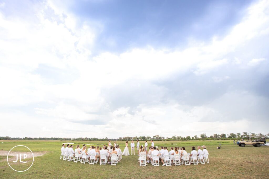 Wide shot of a luxury safari wedding Botswana ceremony layout with a circular seating arrangement on the plains.