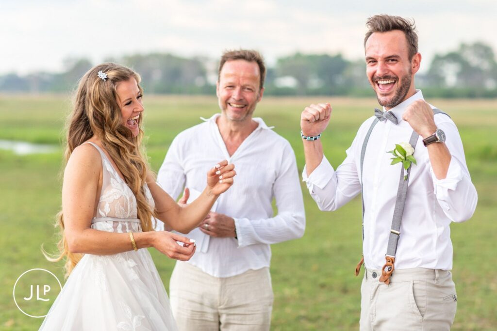 Candid safari wedding photography of a bride and groom celebrating excitedly during their island ceremony.