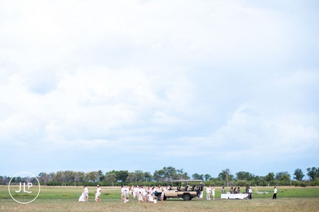 A wide landscape shot of a luxury safari wedding Botswana reception setup on the open savanna.