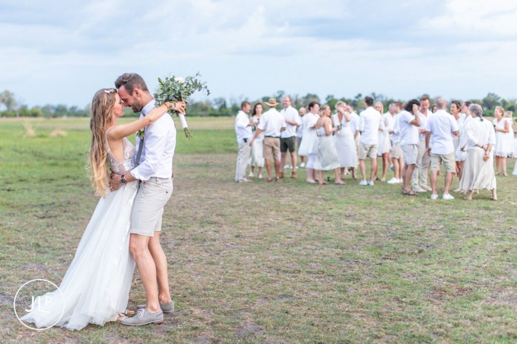 A romantic portrait of the newlyweds holding hands on the floodplains, by an Africa wedding photographer.