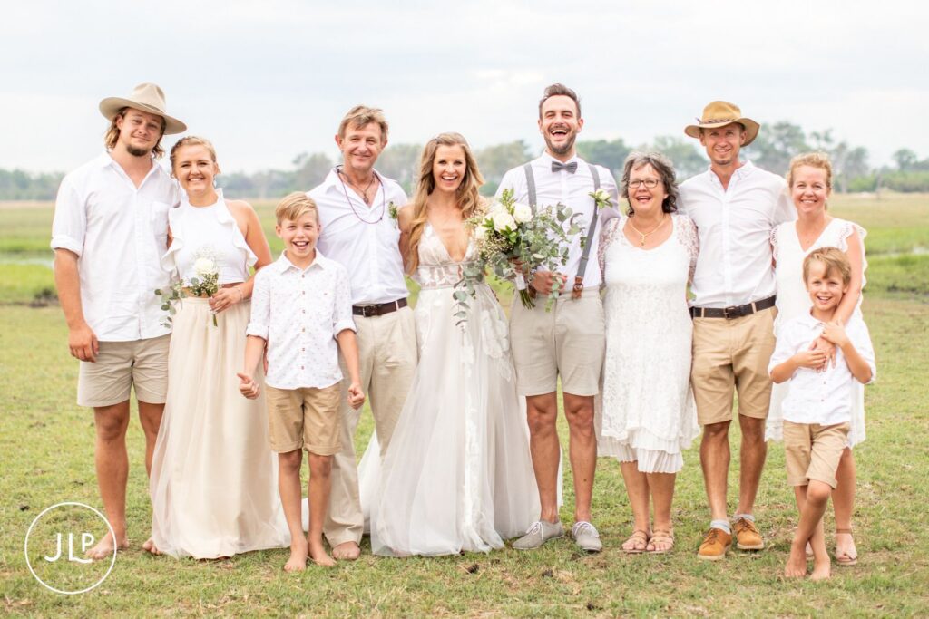 A happy group family photo on the open savanna, captured by an Africa wedding photographer.