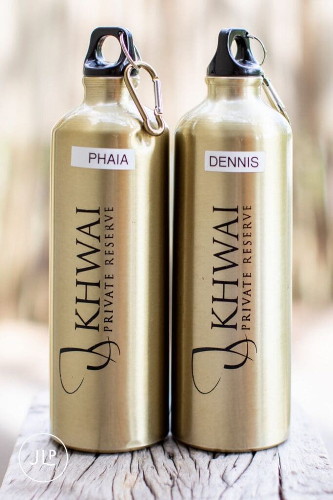 Personalized gold water bottles inside Khwai Private Reserve captured by a Botswana safari wedding photographer.
