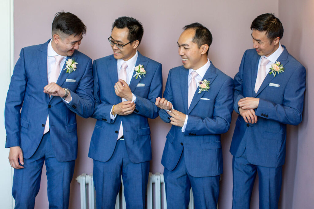 Groom and groomsmen adjusting suit cufflinks 