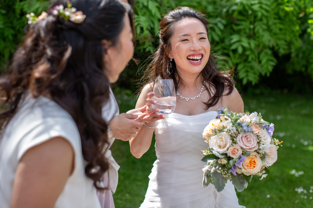 Bride laughing with wedding guest 