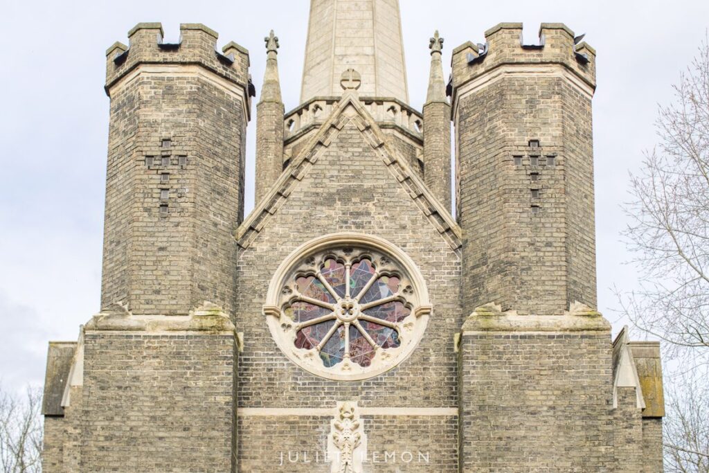 The exterior of newly refurbished Abney Park Chapel with ornate stain glass windows and beautifully restored stone work