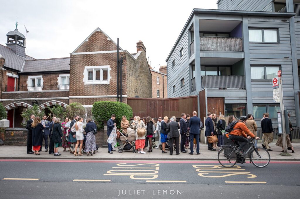 Wedding guests with a pram gather on a Stoke Newington street in Hackney. 