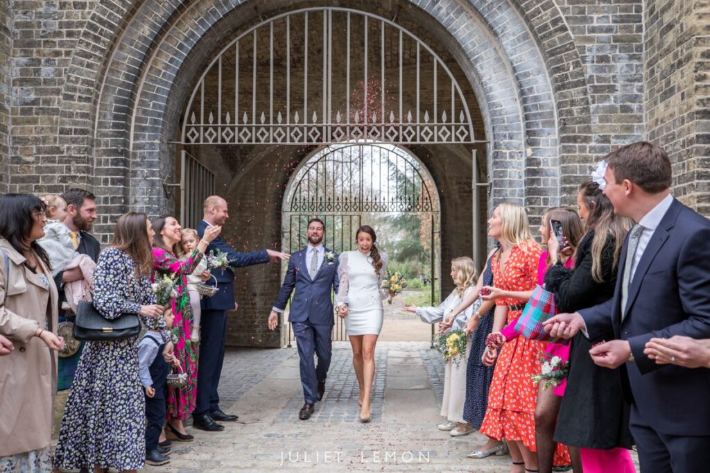 Natural wedding photography London as the couple is showered in confetti at Abney Park