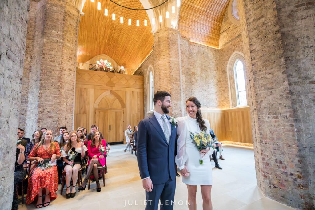 Abney Park Chapel wedding photography of the couple smiling at each other during their ceremony in Hackney.