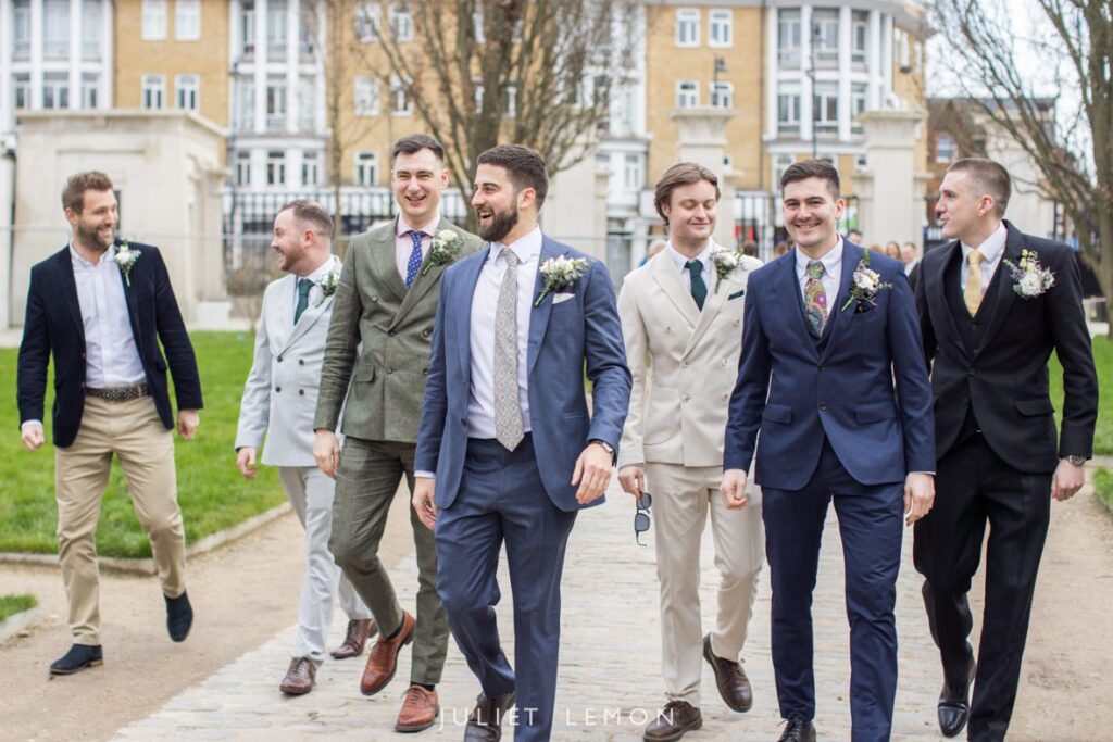 The groom and his groomsmen walk along the path, a natural shot from a London wedding photographer.