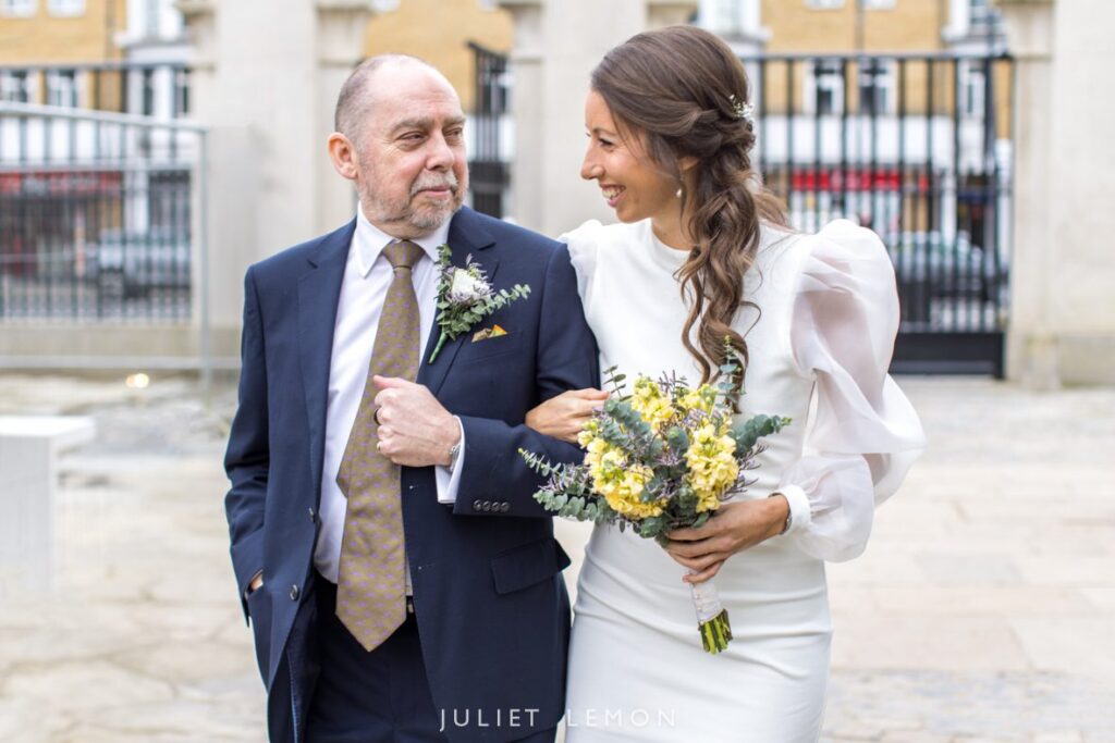 Abney Park Chapel wedding photography of the bride walking with her father toward the ceremony.