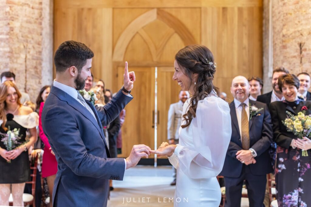 Candid wedding photography London of the couple laughing during the ring exchange at Abney Park Chapel.