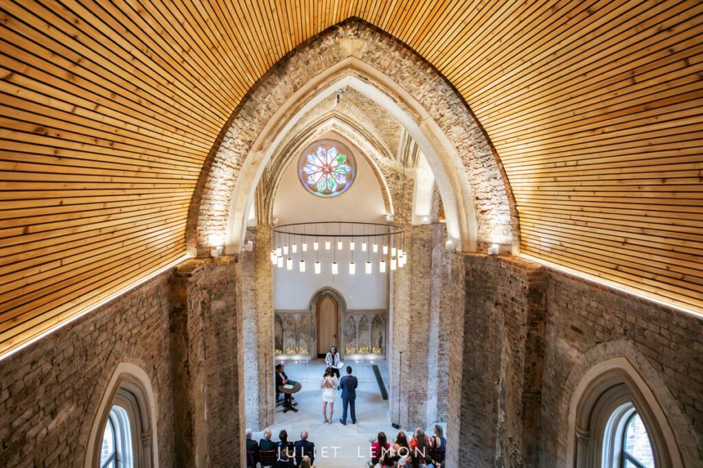 Wide shot of the ceremony interior by an Abney Park Chapel wedding photographer, highlighting the historic arches.
