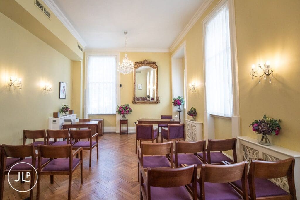 Empty elegant ceremony room setup with purple chairs inside the Chelsea registry office wedding venue.
