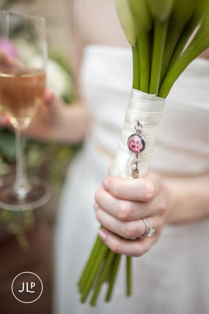 Close-up of a bridal bouquet featuring a sentimental photo charm at a Chelsea registry office wedding.