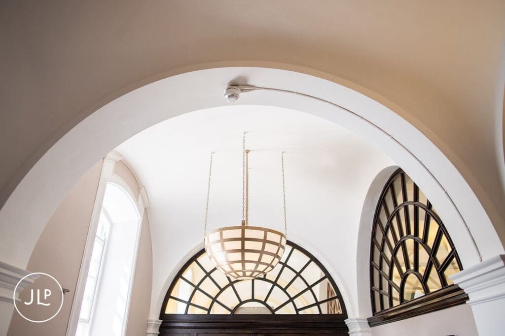 Architecture detail showing the white arched ceiling and chandelier inside Chelsea Old Town Hall.