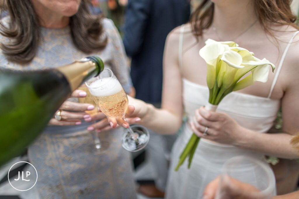 Close-up of chilled champagne being poured for the bride at her Daphne’s Chelsea wedding breakfast.