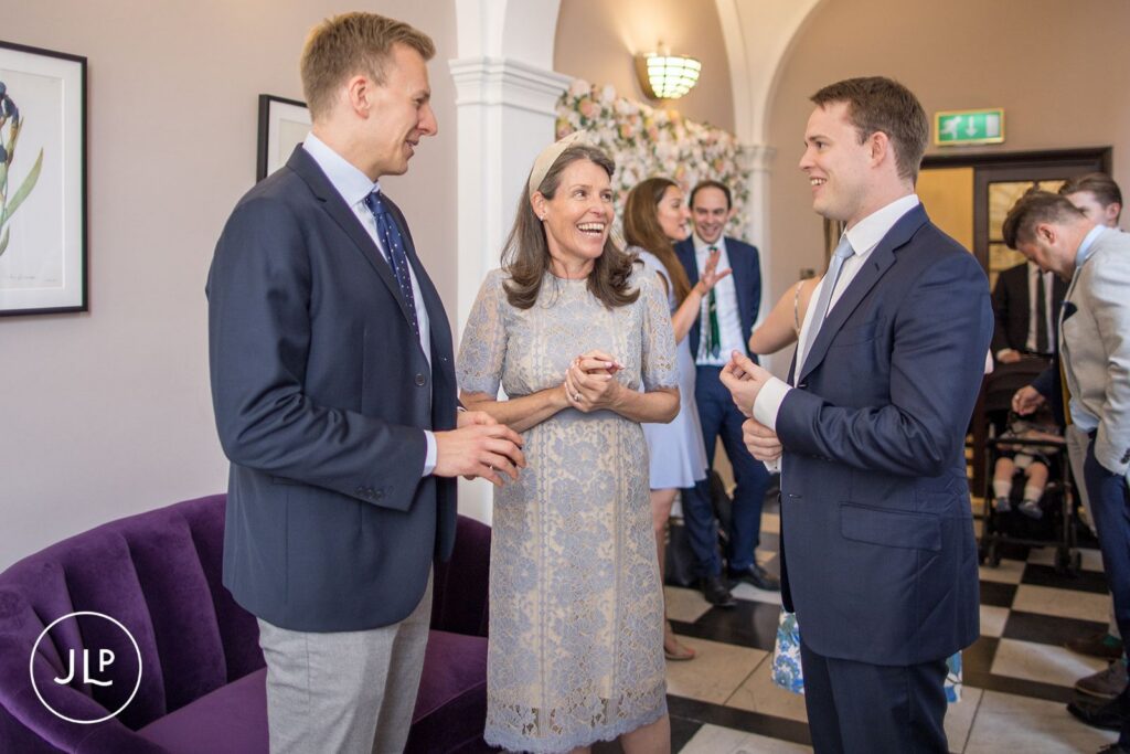 Guests mingling and laughing in the lobby during an elegant Chelsea Town Hall wedding.