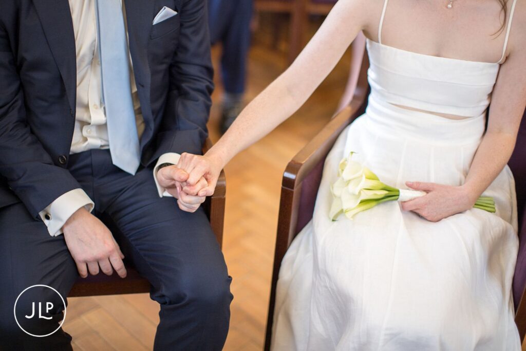 Groom and bride seated during their London registry office wedding.