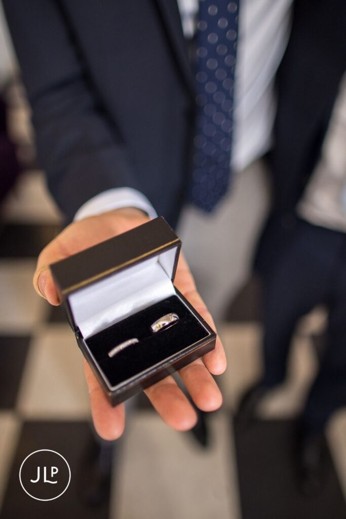 Close-up of silver wedding bands in a black velvet box.