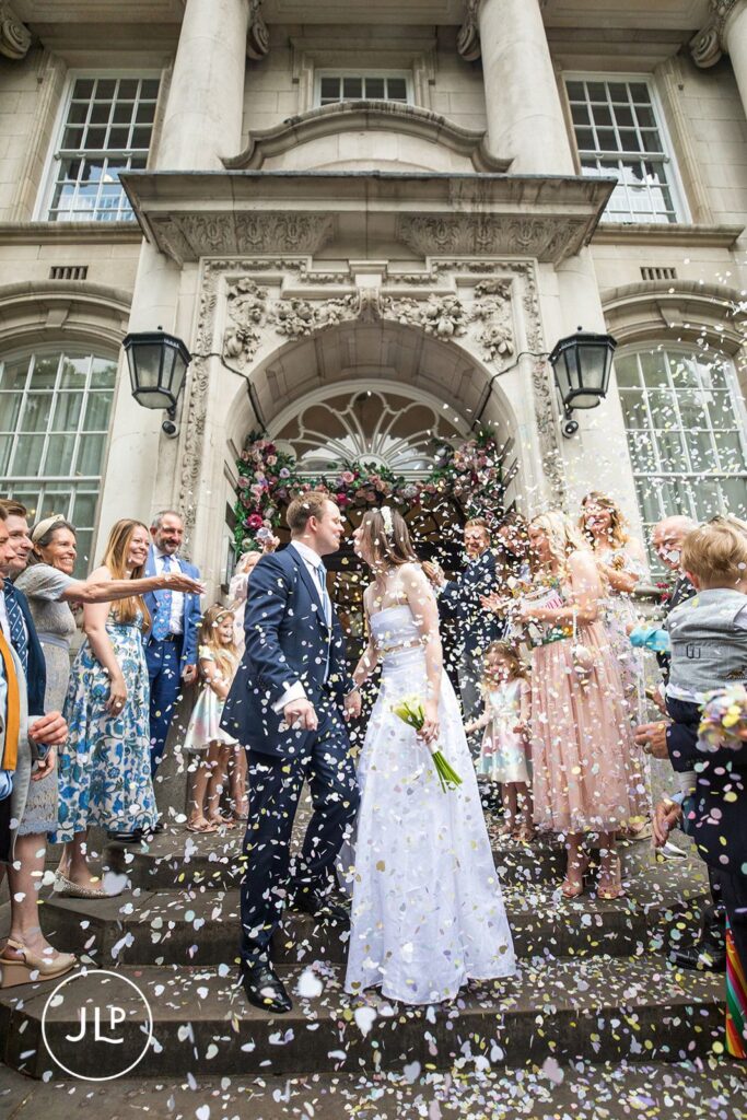 Iconic confetti moment on the stone steps of Chelsea Old Town Hall.