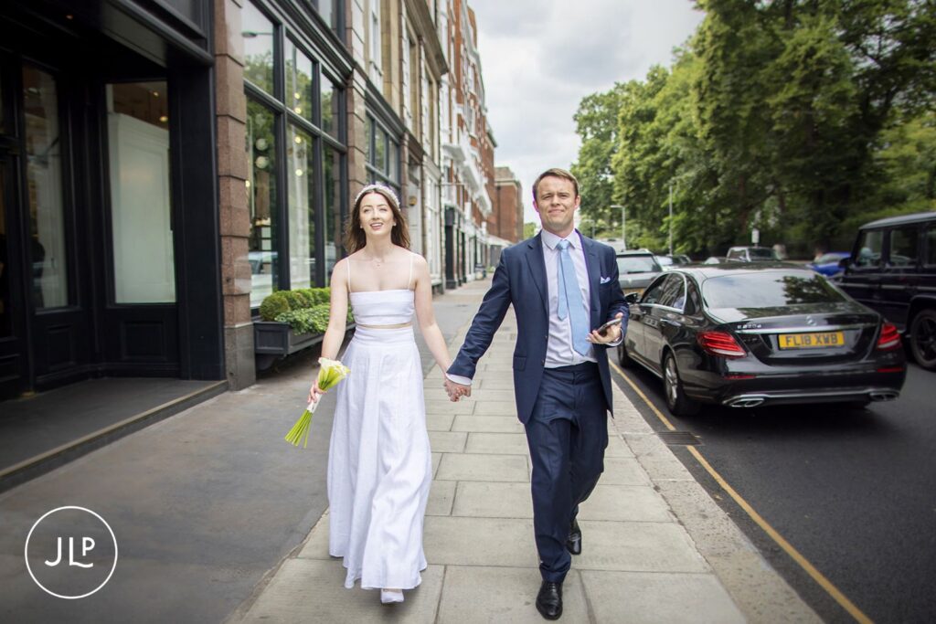 Bride and groom strolling through Chelsea towards their wedding breakfast at Daphne's.