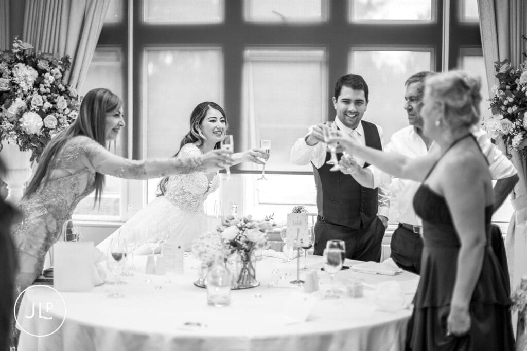 A black and white image of the head table raising a glass in a toast.