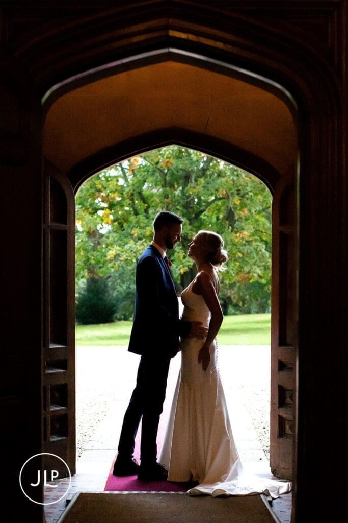 Silhouette of a bride and groom in a doorway, captured by a Hartsfield Manor wedding photographer.