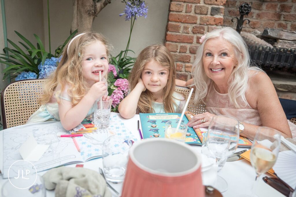 Children and a guest enjoying coloring books during a relaxed intimate London wedding reception.