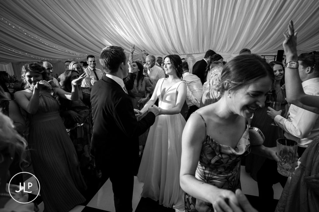 Dynamic wide shot of the wedding party dancing at a Surrey countryside wedding.