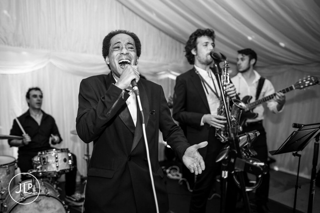 Live band performance inside the marquee, a highlight of marquee wedding photography UK.