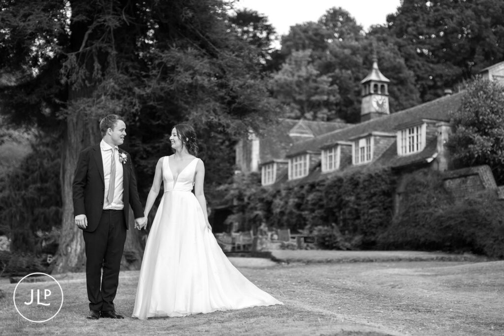 Black and white portrait of the couple walking on the lawn at a luxury outdoor wedding Surrey.