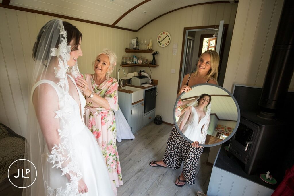 Bride's mother adjusting lace veil, a candid moment of a private estate wedding Surrey.