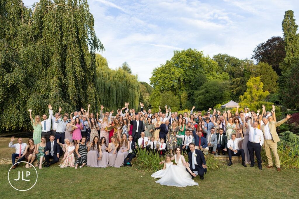 Large group photo of guests cheering at a luxury Surrey marquee wedding.