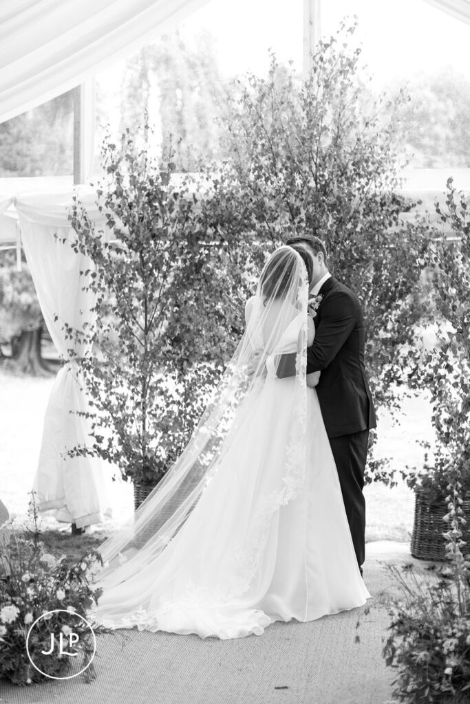 Black and white candid of the couple’s first kiss at a private estate wedding Surrey.