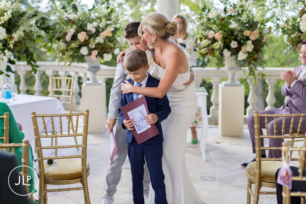 Bride hugging children, professional Buckinghamshire wedding photographer candid shot.
