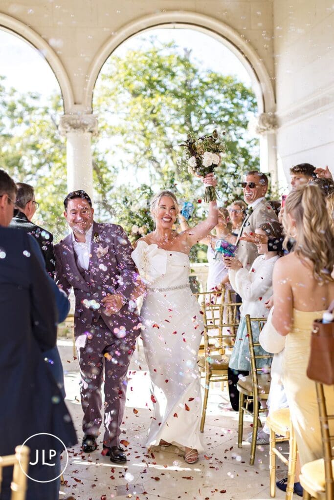 Bride and groom celebrating through bubbles at Cliveden House.