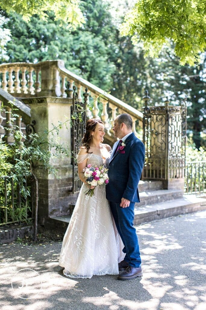 A bride and groom sharing a loving glance together by an ornate stone staircase at York House.