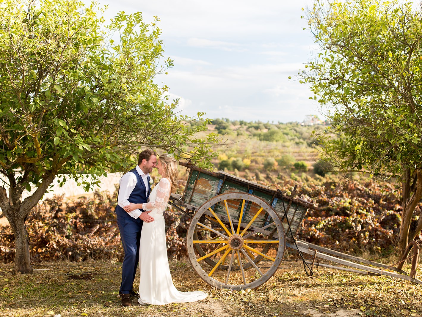 Ali and Matty by a rustic cart at Quinta dos Vales, captured by a Portugal destination wedding photographer.