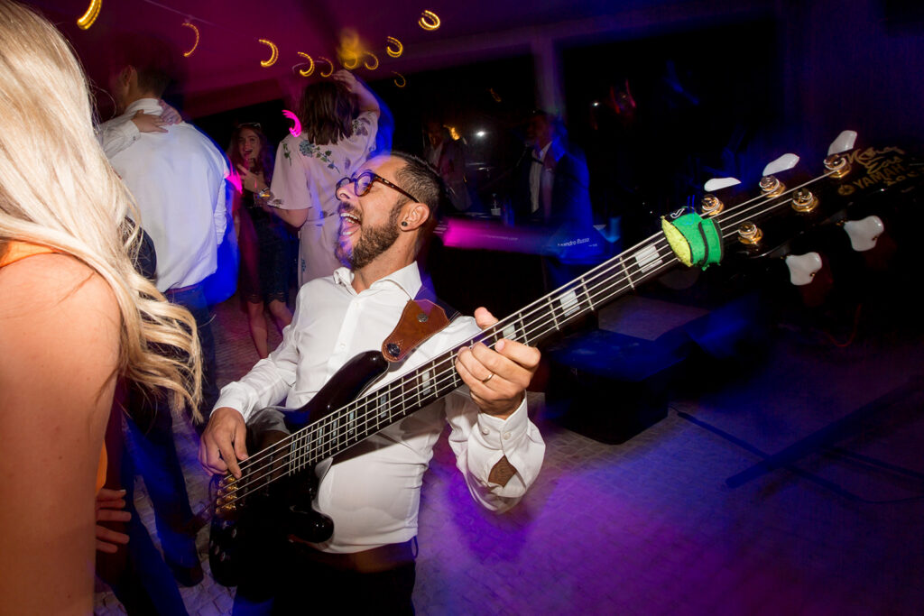 Live band bassist performing during an energetic evening celebration at Quinta dos Vales, Portugal.