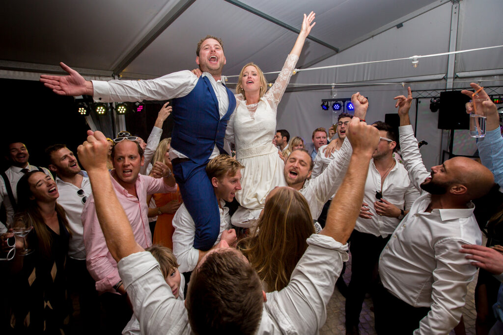 Ali and Matty crowd surfing during their vibrant luxury Algarve wedding party at Quinta dos Vales.