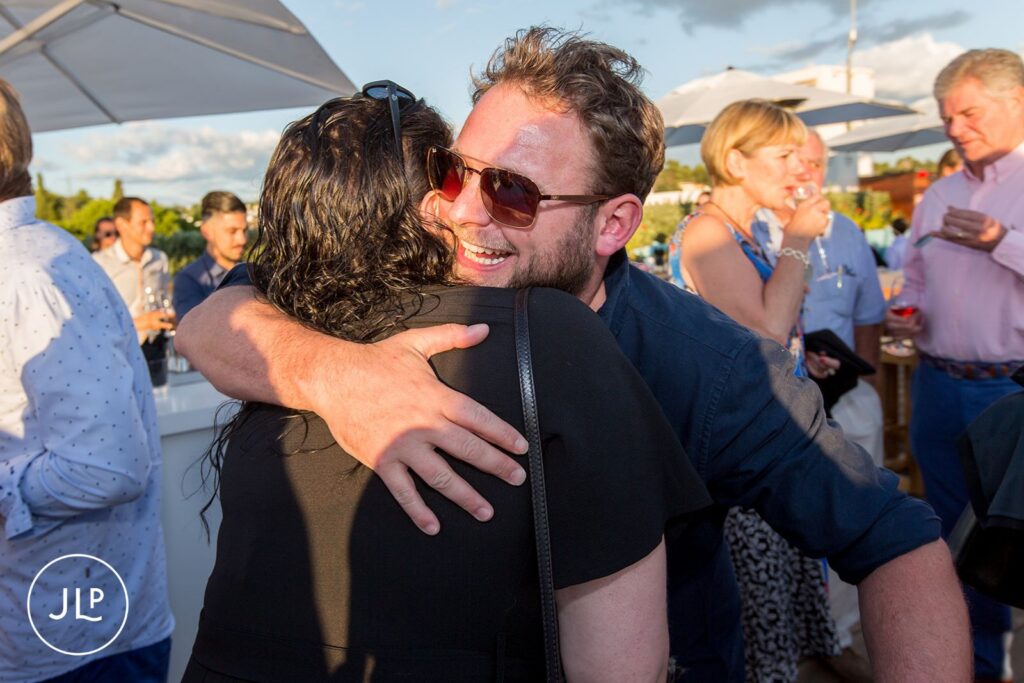Candid moment captured by a Portugal destination wedding photographer at a sunset party.