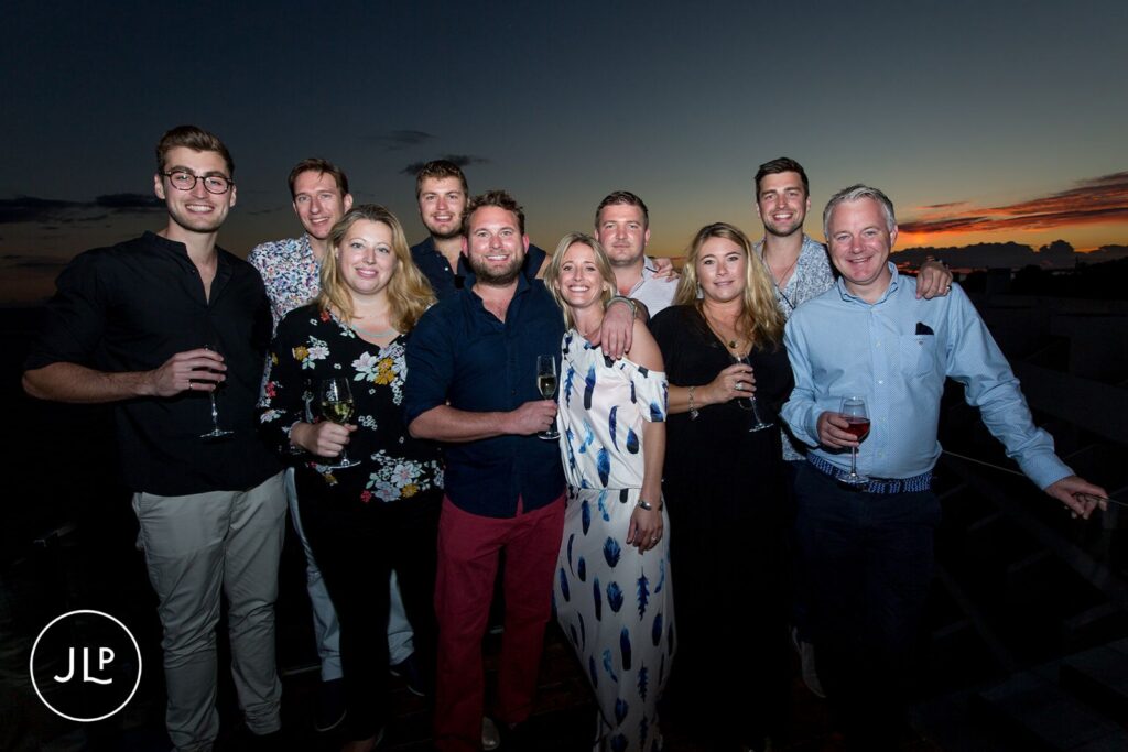 Wedding party group photo at Sky Bar Carvoeiro sunset event by an Algarve welcome party photographer.