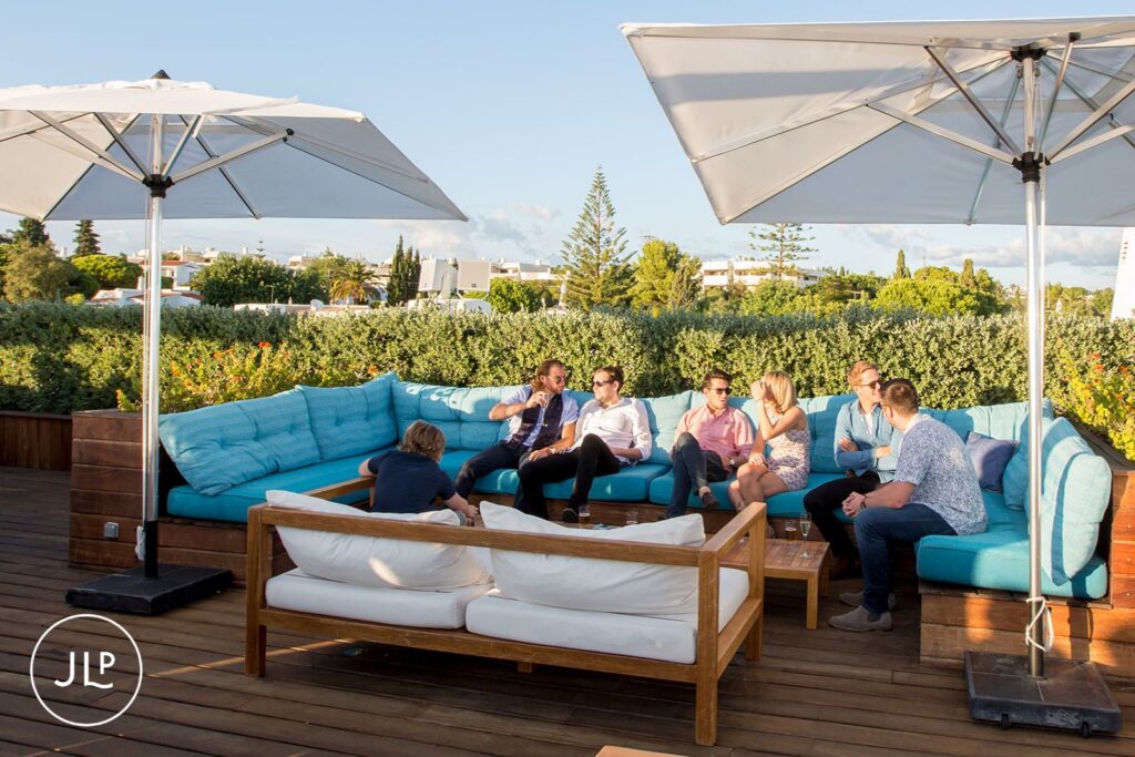 Men relaxing on a rooftop terrace during a luxury Algarve wedding weekend celebration.