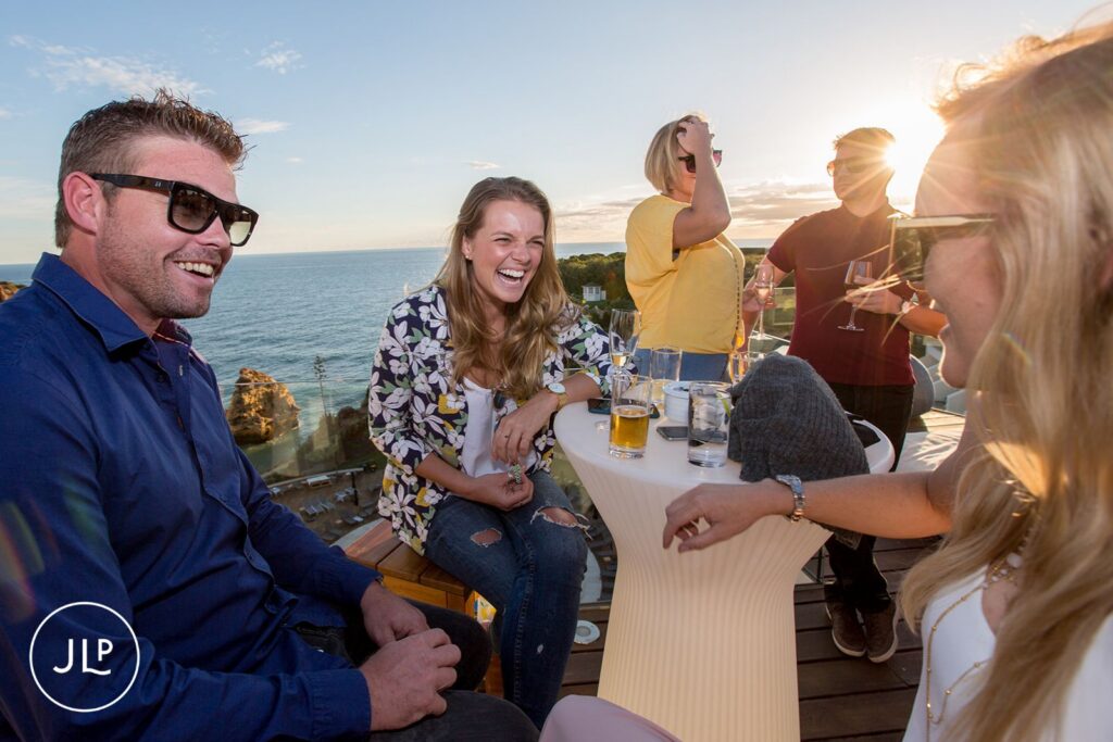 Candid guest laughter during an Algarve rooftop party at the Tivoli Carvoeiro hotel.