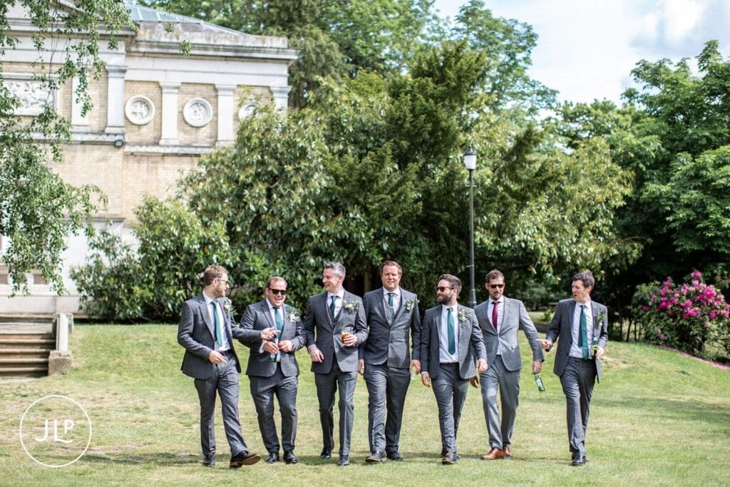 Groomsmen walking outside Hampton Court House weddings captured by a London wedding photographer.